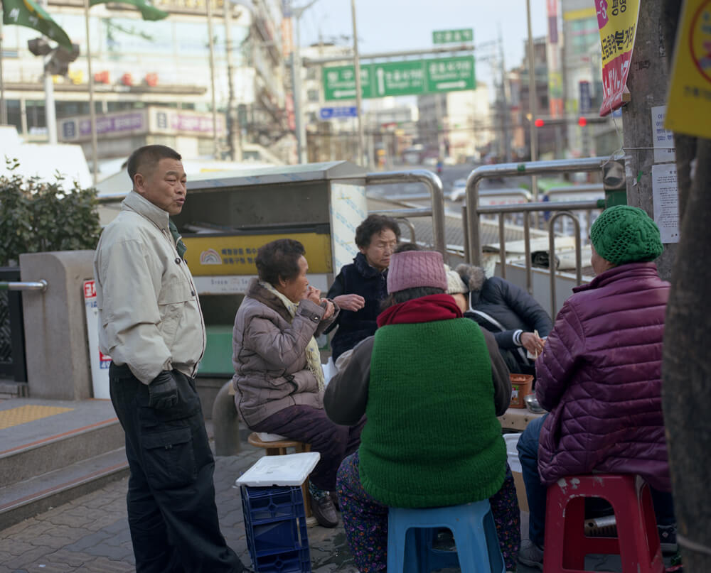 路上で食事をする韓国の人々